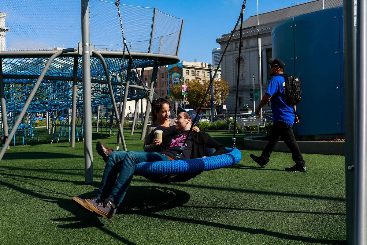 Jessie Cooper and Justin Roth embrace on a swing at a playground at Civic Center in San Francisco, California, on Sunday, Oct. 21, 2018.