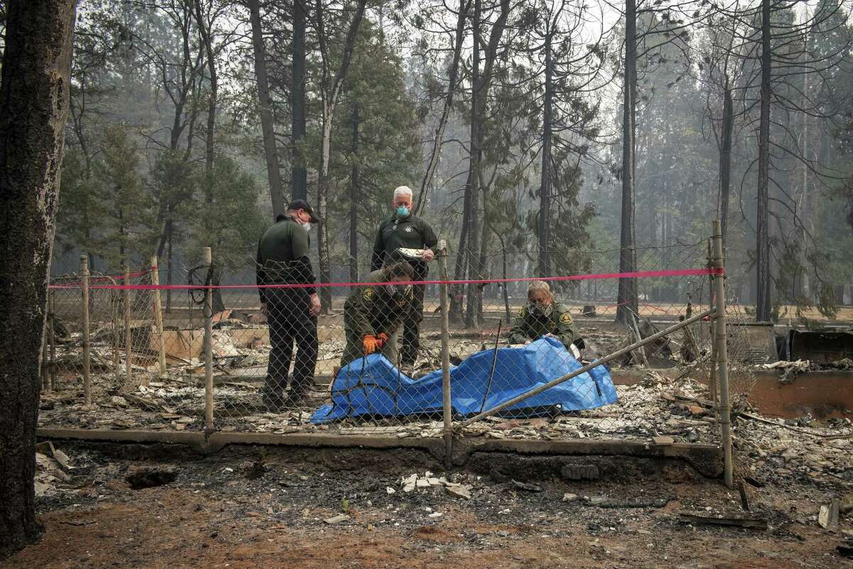 Butte County and Fresno County Sheriff officers prepare to remove the remains of a victim of the Camp Fire in Magalia, California, on Nov. 15, 2018.