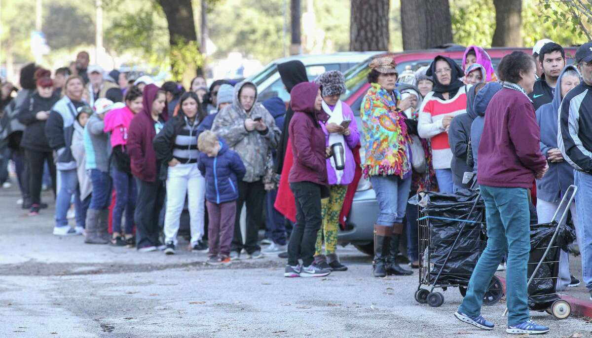People waited in the cold to receive free food at the East Spring Branch Food Pantry Tuesday, Nov. 20, 2018, in Houston. The food pantry served at least 1,000 families a Thanksgiving meal on Tuesday morning. The pantry provided a turkey (or chicken), a large bag of produce, and bags of non-perishable food to hundreds of families in need.