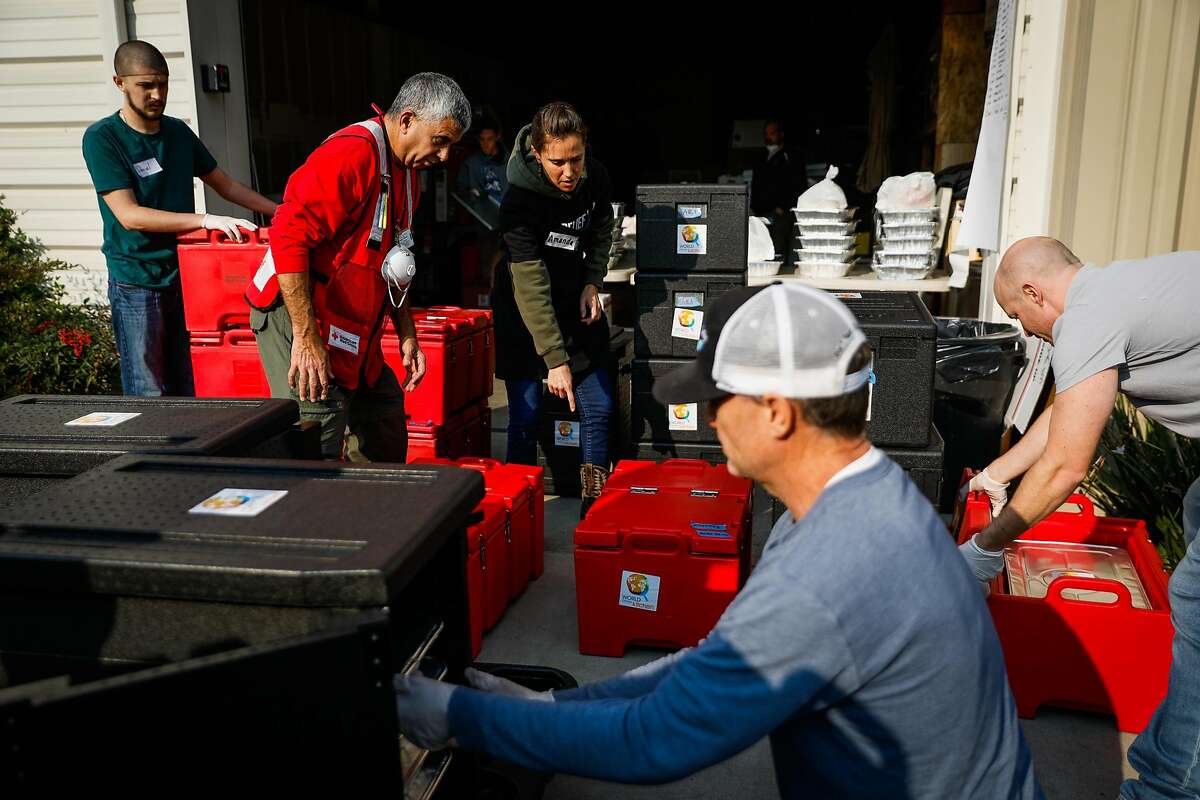 Volunteer Amanda Masula (center) organizes the transportation of food for those who were affected and displaced by the Camp Fire in Chico, California, on Tuesday, Nov. 20, 2018.