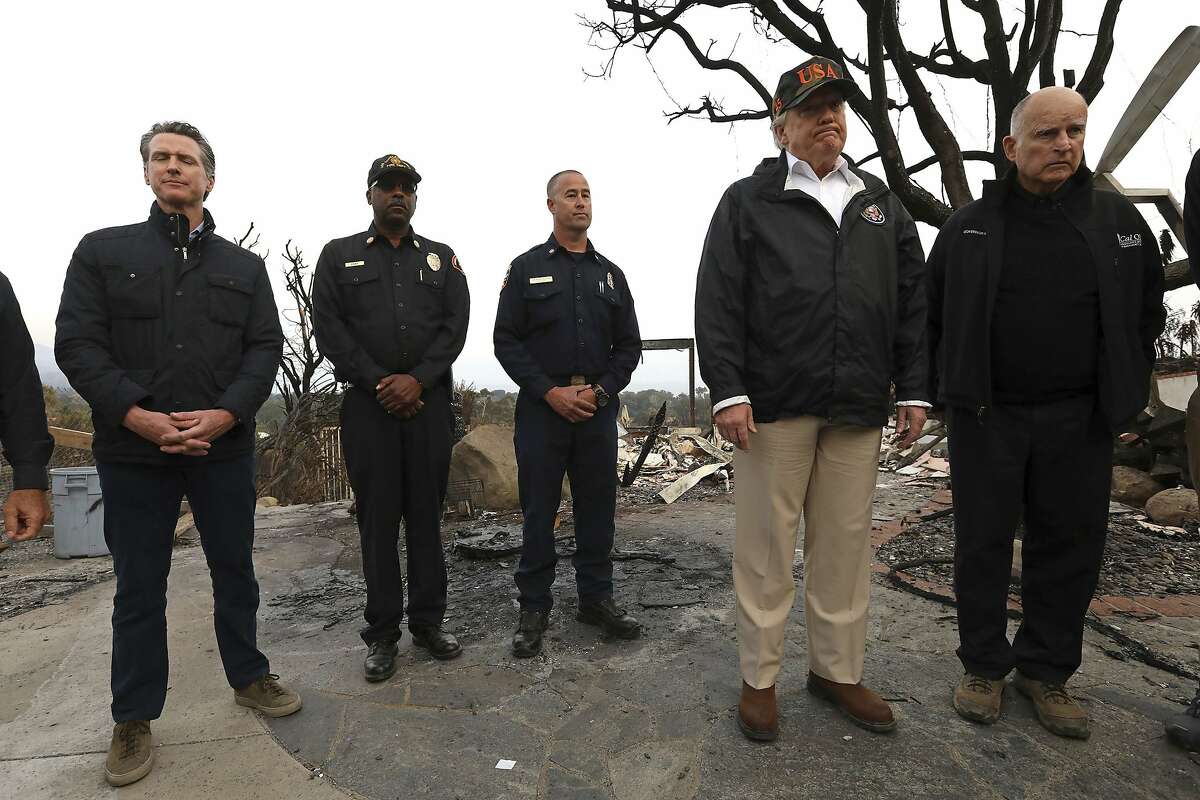 President Donald Trump, second from right, reacts while taking in the damage from the Woolsey Fire alongside California Governor-elect Gavin Newsom, from left, Los Angeles County Fire Chief Daryl Osby, Cal Fire Deputy Chief Nick Schuler and California Governor Jerry Brown in Malibu, Calif., on Saturday, Nov. 17, 2018. Trump arrived at the oceanside conclave Saturday afternoon after visiting Northern California to survey the damage from the Camp Fire in the town of Paradise. (Genaro Molina/Los Angeles Times via AP, Pool)