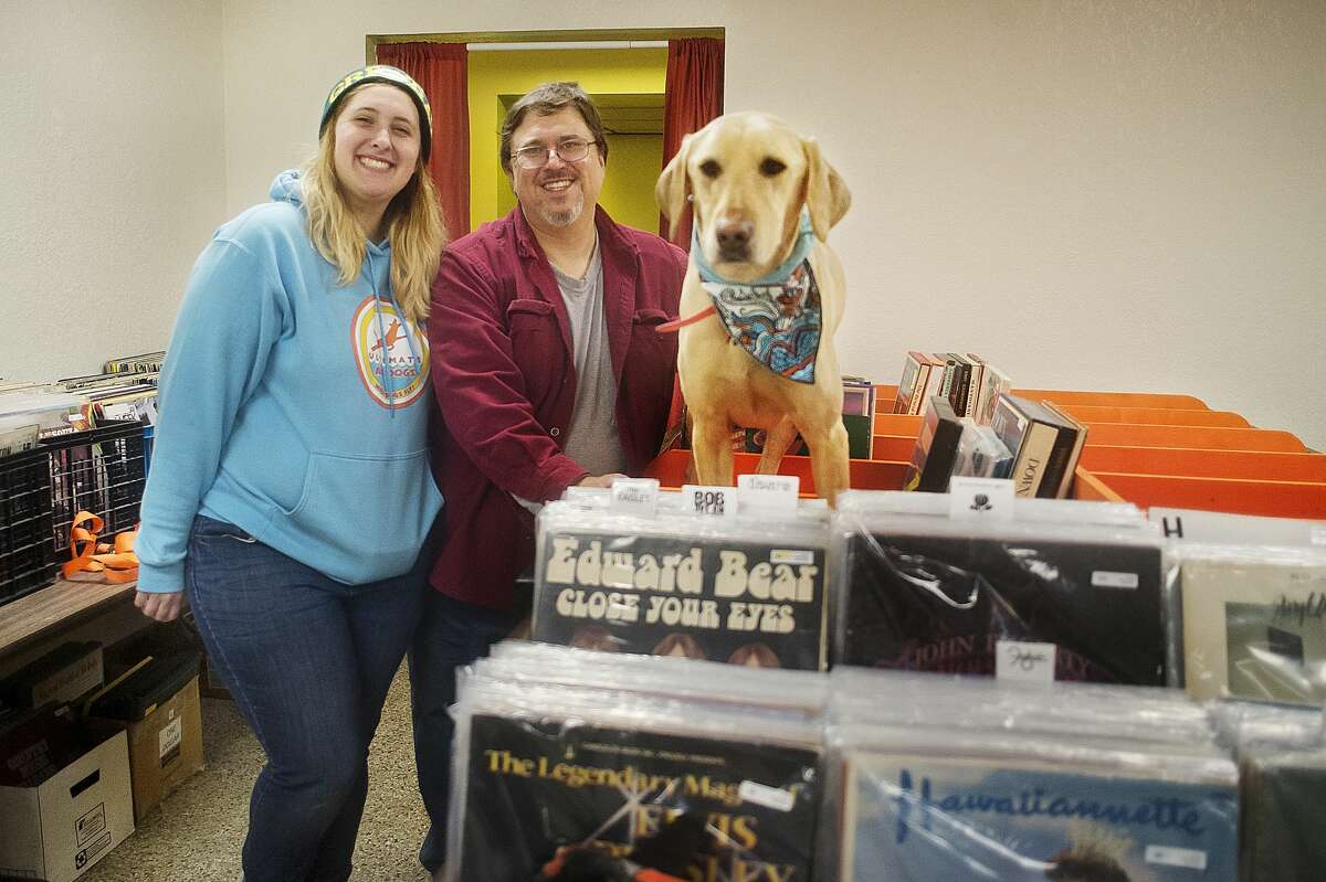 Katie Gleason, left, Jim Gleason, center, and their dog Blue pose for a portrait inside their record store, Radio Wasteland, on Tuesday in Midland. (Katy Kildee/kkildee@mdn.net)