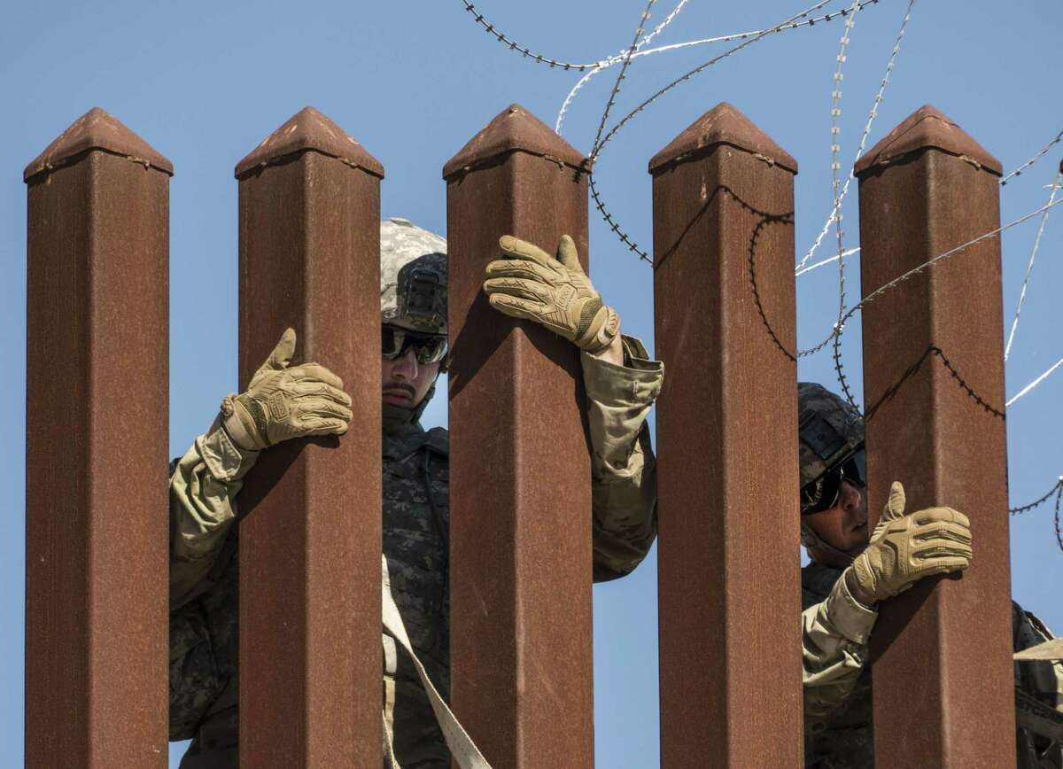 Soldiers of the 41st Route Clearance Company, 4th Engineer Battalion, who are currently based at Camp Donna, place concertina wire on a barrier at the McAllen-Hidalgo International Bridge on the U.S.-Mexico border on Friday, Nov. 16, 2018.