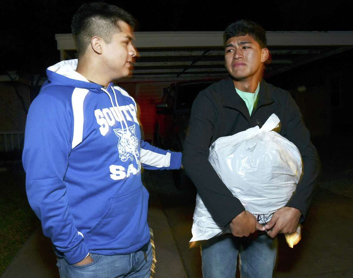 Shane Onofre, left, comforts his friend, Andy Guevara, Jr., whose family home burned on Monday. Onofre and friends b brought donations for the Guevara family on Wednesday night, Nov. 21, 2018.