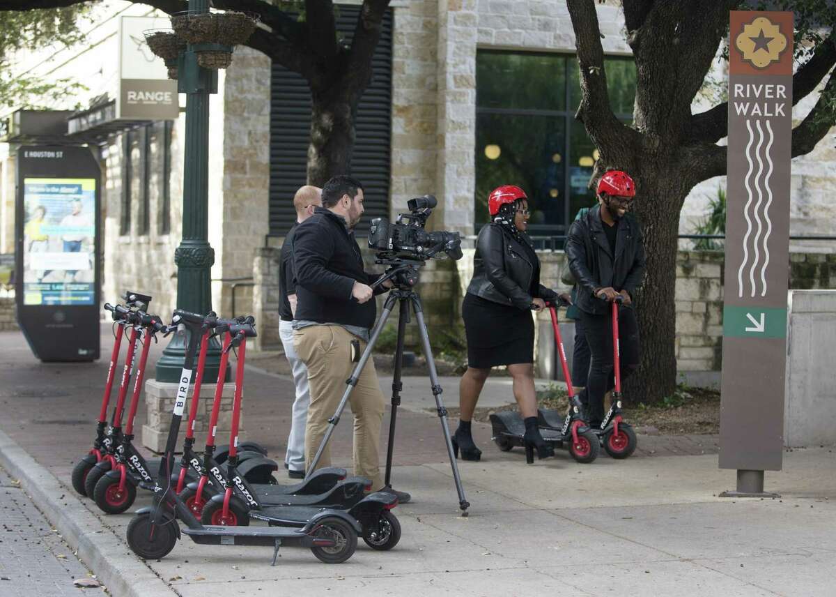 Photographer Francisco Navarro, left, films actors Christian Reed-Ogba, center, and Uche Ogba Tuesday afternoon as they shoot a PSA for the city about e-scooter etiquette and rules.