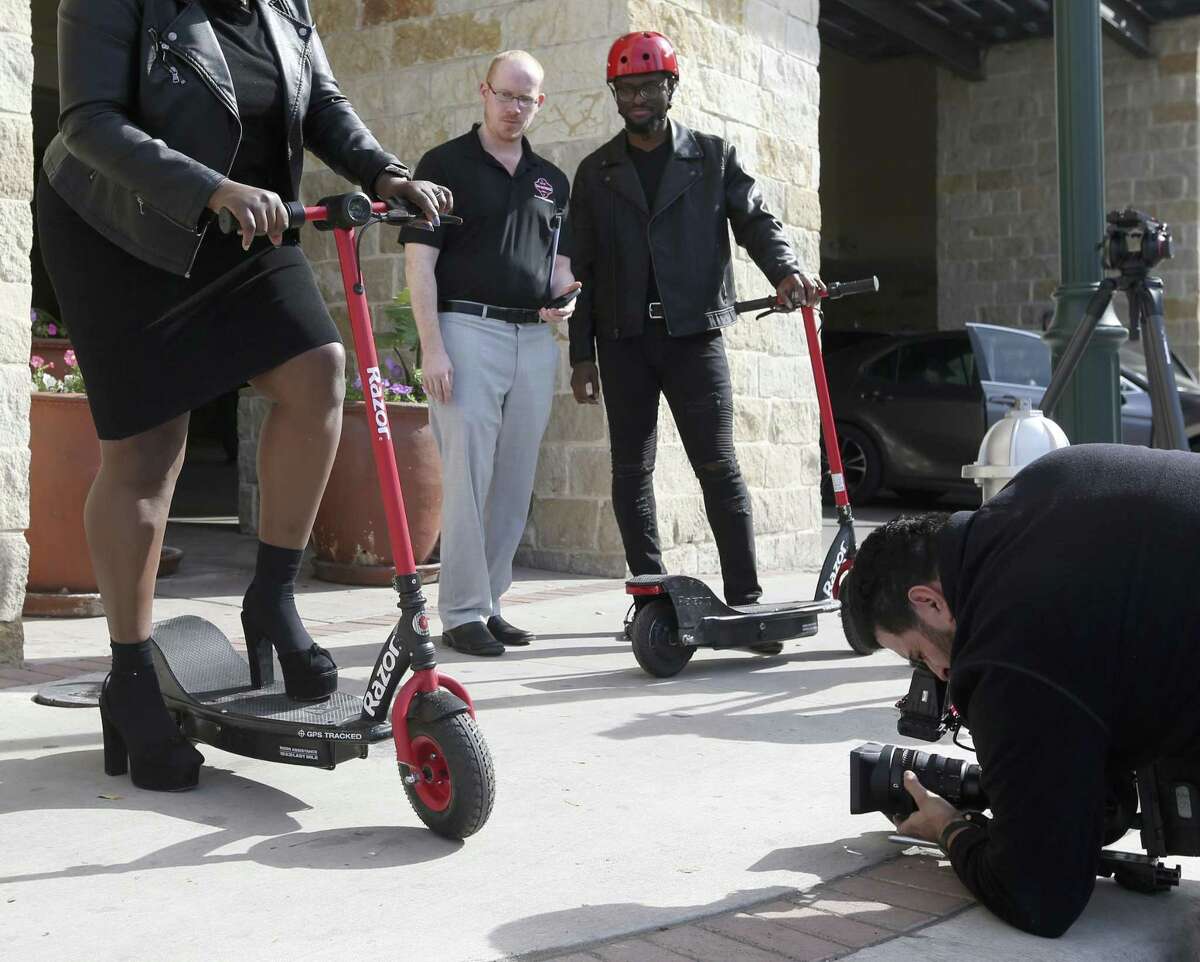 Photographer Francisco Navarro, right, films actor Christian Reed-Ogba as David McElroy, second from left, and Uche Ogba watch during the filming of a City of San Antonio sponsored-PSA about e-scooter etiquette and rules.