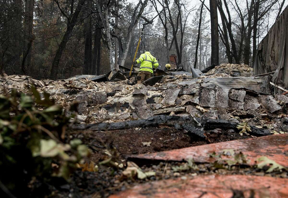 Search and rescue teams sift through the rubble for human remains as the rain falls along Pearson Road in Paradise, Calif. Wednesday, Nov. 21, 2018 after the Camp Fire devastated the entire town.