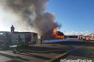 Fire burning through big rigs sends smoke into West Oakland