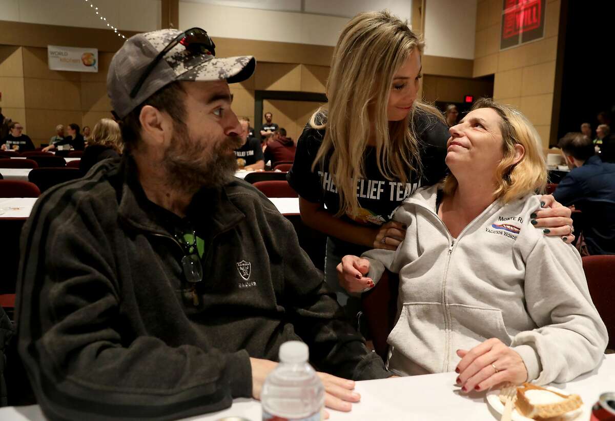 Volunteer Chrystal Axelsson, middle, greets Paradise residents Chuck Campos, left, and his wife Pamela Monchamp during the Thanksgiving Together event at Chico State on Thursday, Nov. 22, 2018. Campos and Monchamp, who lost their home in the Camp Fire, were regulars at Axelsson's restaurant, which survived the fire.