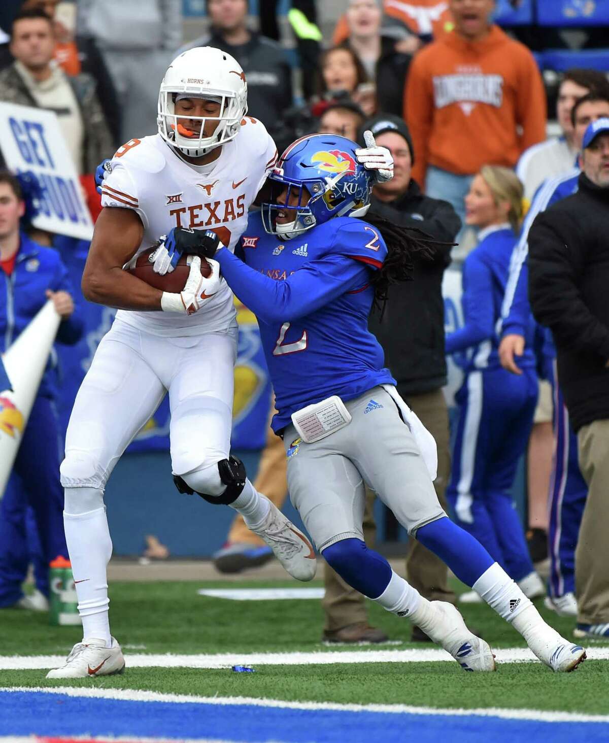 LAWRENCE, KANSAS - NOVEMBER 23: Wide receiver Collin Johnson #9 of the Texas Longhorns goes in for a touchdown against cornerback Corione Harris #2 of the Kansas Jayhawks in first quarter at Memorial Stadium on November 23, 2018 in Lawrence, Kansas.