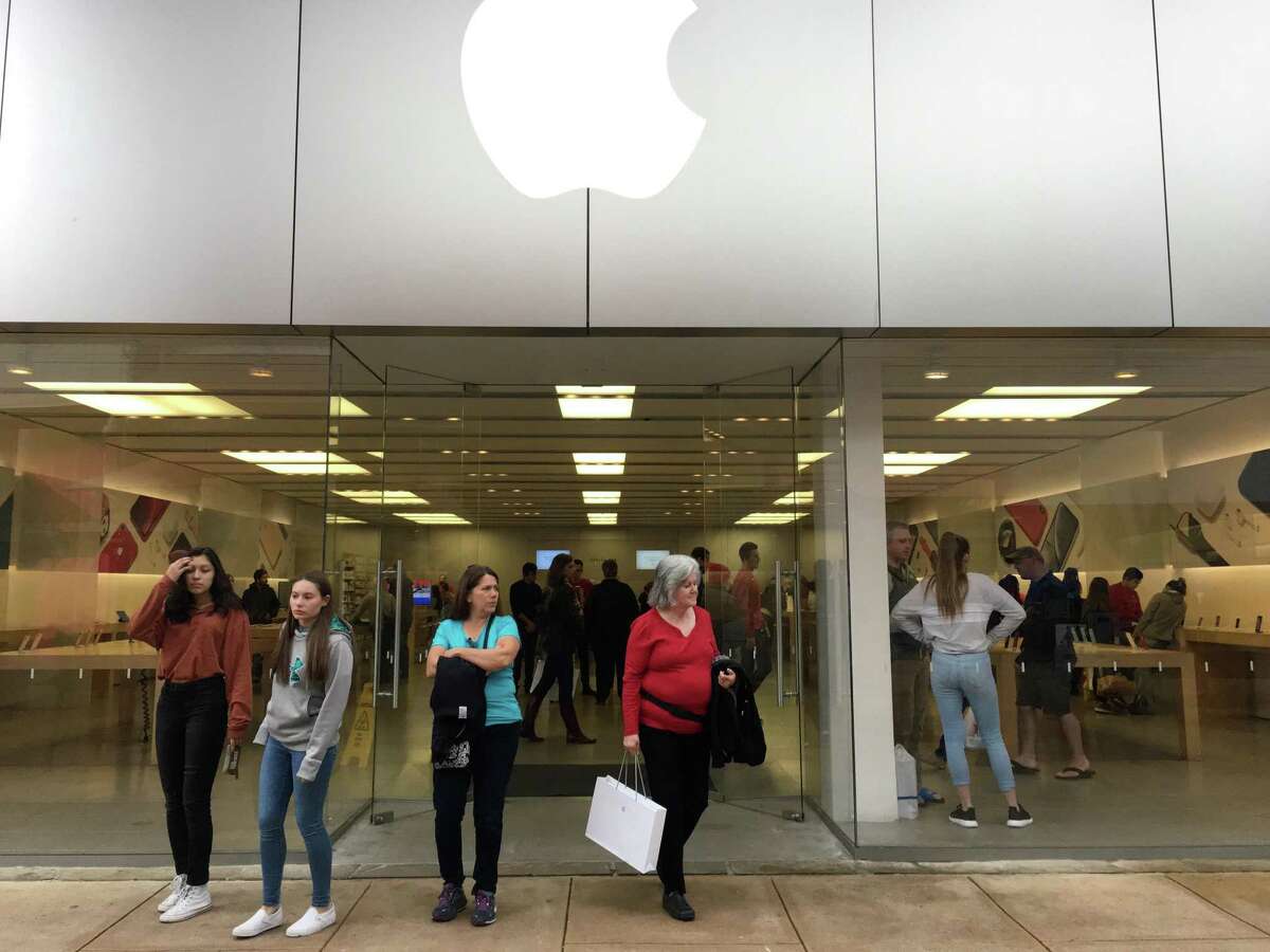 Shoppers exit the Apple Store at the Shops at La Cantera on Black Friday in 2018. Apple recently re-closed the store and another location at North Star Mall as COVID-19 cases surge in the area.