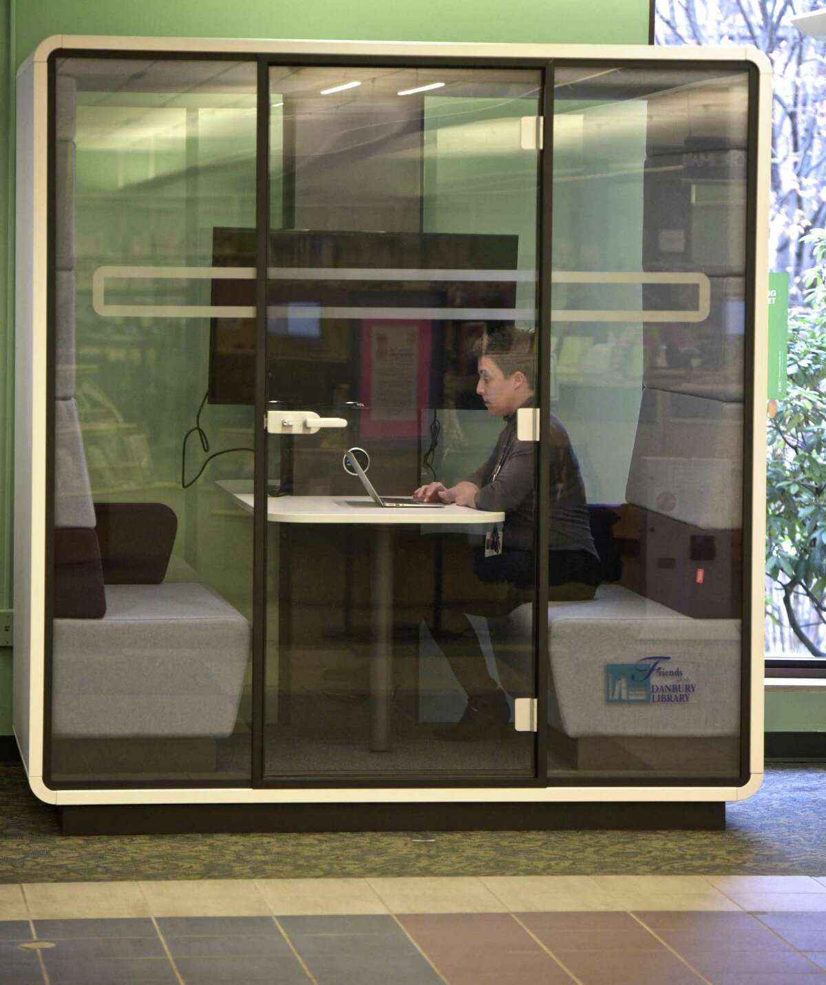 Digital Servies Librarian Amanda Gilbertie demonstrates the new meeting pod at the Danbury Public Library.
