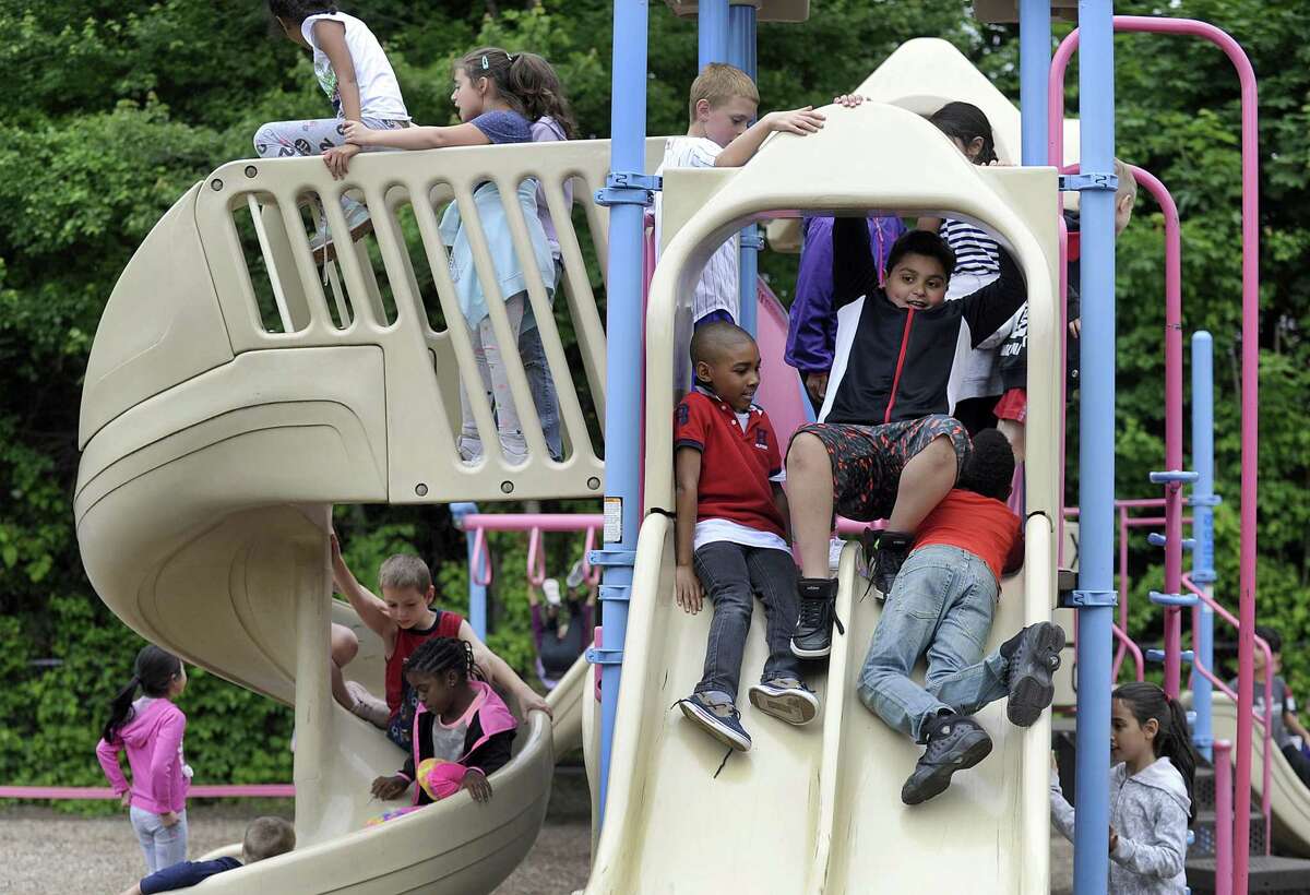 Justin Brown, 8, and Ayaan Mufti, 9, slide down the slide during recess Wednesday, June 6, 2018. Parents and teachers at Pembroke Elementary in Danbury, are trying to raise $150,000 for a new playground and park at the school that would be more accessible to the schools 90 special needs students.