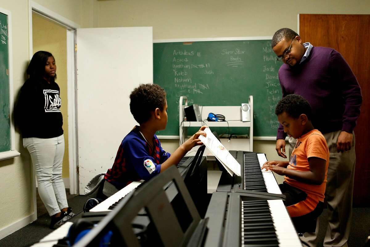 Rev. James Smith (right) helps Arkadeus Hailu, 8, during the Bridge to Arts and Music program at the Third Baptist Church on Wednesday, Nov. 14, 2018, in San Francisco, Calif.