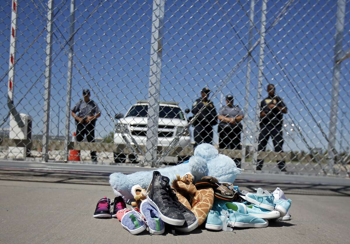 FILE- In this June 21, 2018, photo shoes and a teddy bear, brought by a group of U.S. mayors, are piled up outside a holding facility for immigrant children in Tornillo, Texas, near the Mexican border. Records obtained by The Associated Press highlight some of the problems that plague government facilities for immigrant youth. (AP Photo/Andres Leighton, File)
