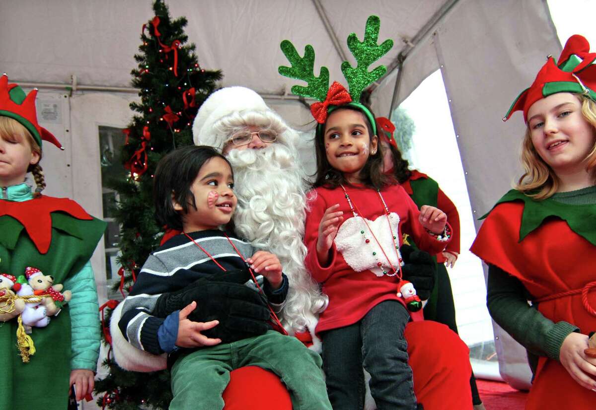 Dhruv Iyer, 3, of Southport, and his sister Moksha 5, visit with Santa on the green at Old Town Hall in Fairfield, Conn., on Saturday Nov. 24, 2018. Santa arrived at 10 a.m. via a firetruck from the Fairfield Fire Department. Along with a petting zoo and horse drawn carriage rides, local businesses and non-profit organizations showcased their products and services in tents and kiosks around the green.