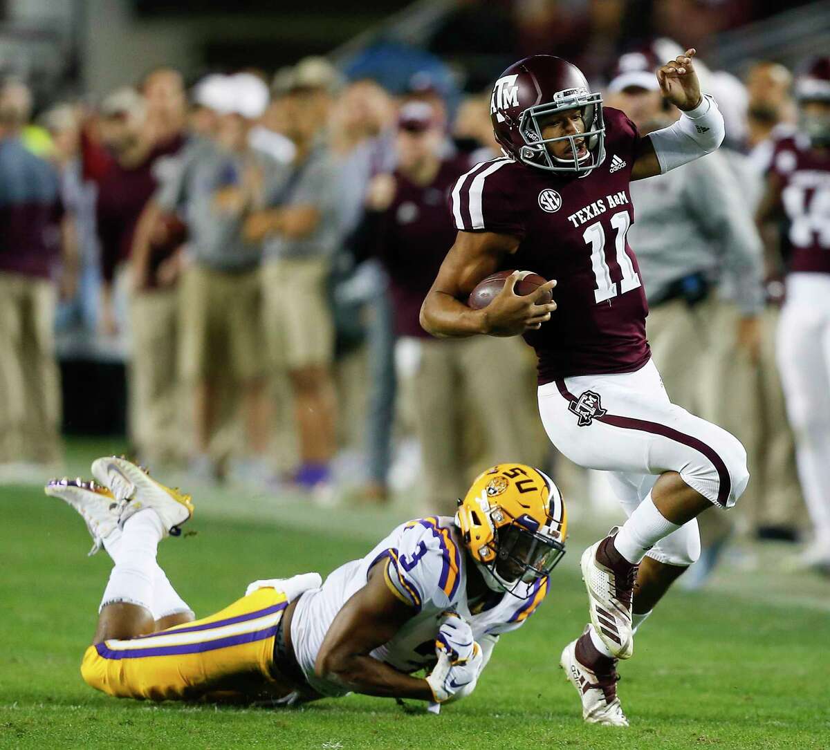 Kellen Mond (11) of the Texas A&M Aggies slips the tackle attempt by JaCoby Stevens of the LSU Tigers in the first half at Kyle Field on Nov. 24, 2018 in College Station.