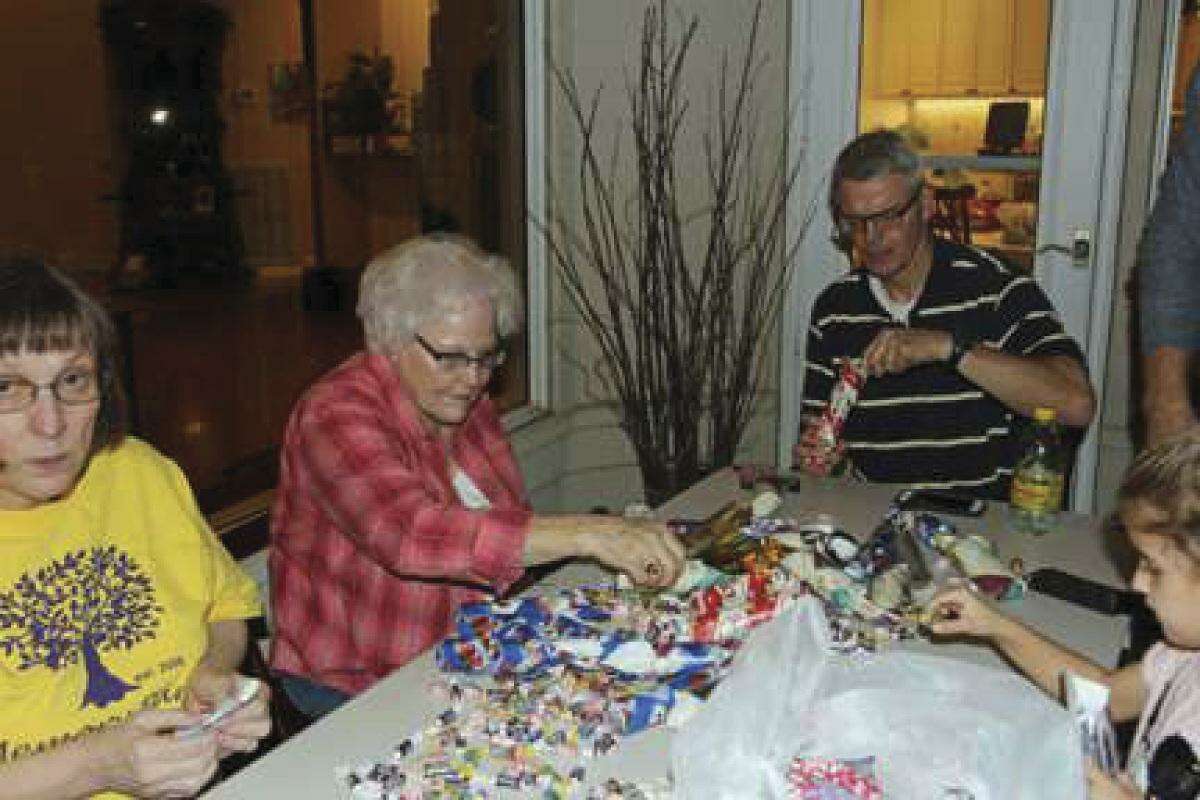 Members of the Rotary Club of Lake Conroe gather to make Christmas Candy Rolls to be delivered to underprivileged children in Mexico.