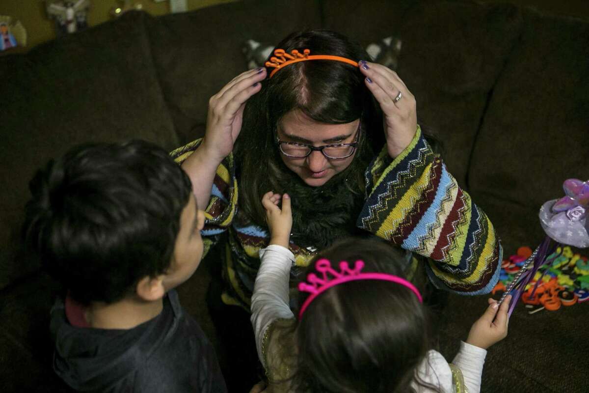 Deanna Sanchez places a plastic crown on her head as she begins to play a game of pretend with her foster children at their home Nov. 15, 2018. She and her husband, John Sanchez, have three foster children now.