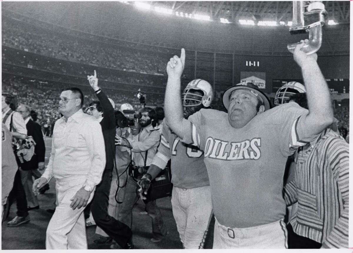 Houston Oilers Roughneck mascot Art Horridge (RIGHT) raises his arms in triumph while escorting coach Bum Phillips off the field after the Oilers 20-17 victory over the Pittsburgh Steelers on Monday night football in the Astrodome on Dec. 10, 1979.