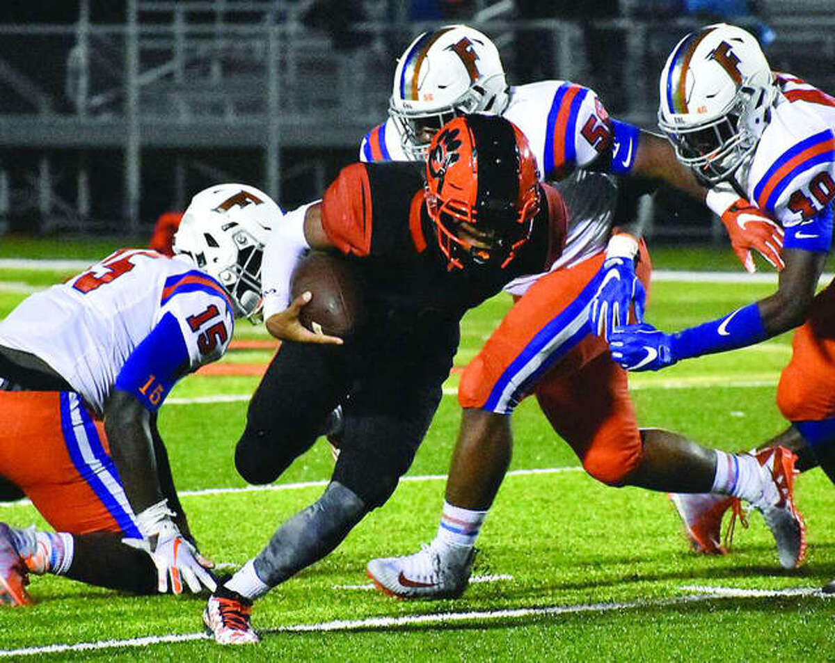 Edwardsville quarterback Kendall Abdur-Rahman (middle) tries to force his way past three East St. Louis defenders during the second quarter of Friday’s Southwestern Conference game at the District 7 Sports Complex in Edwardsville.
