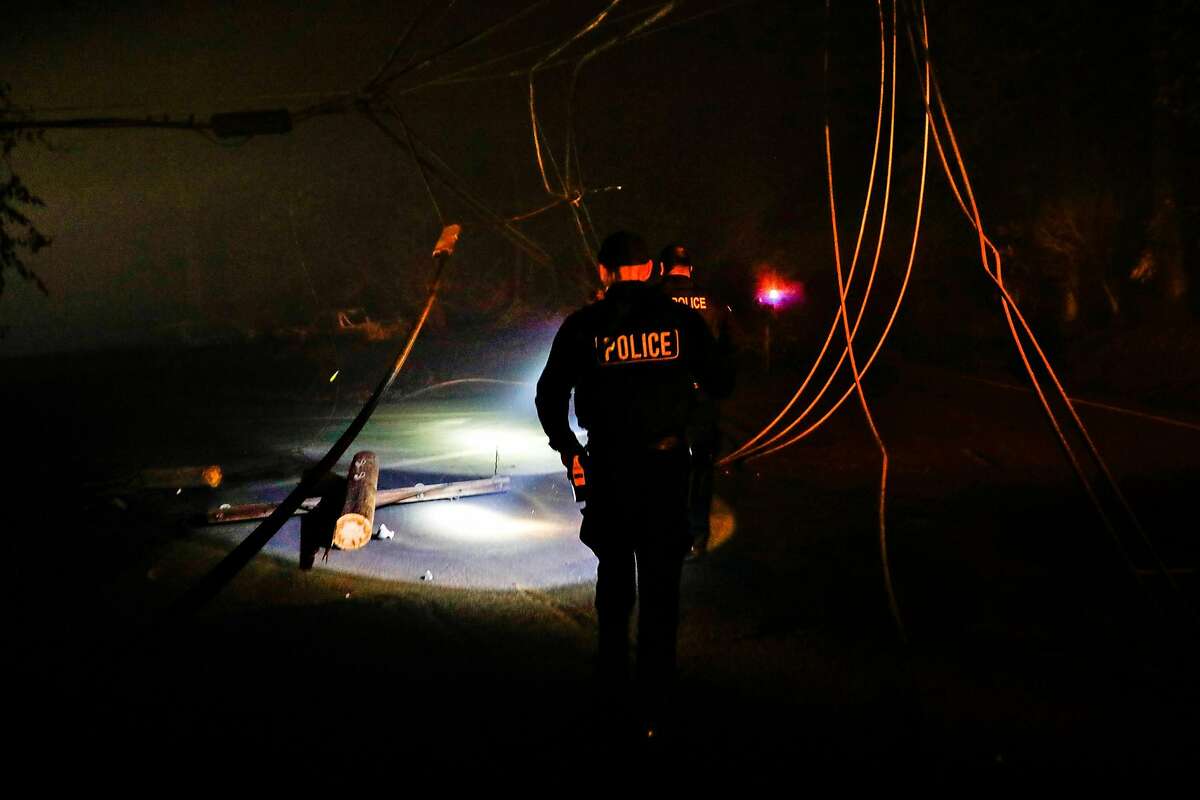 Police officers investigate downed wires on Pearson Road after the Camp Fire ravaged the town of Paradise, California, on Friday, Nov. 9, 2018.