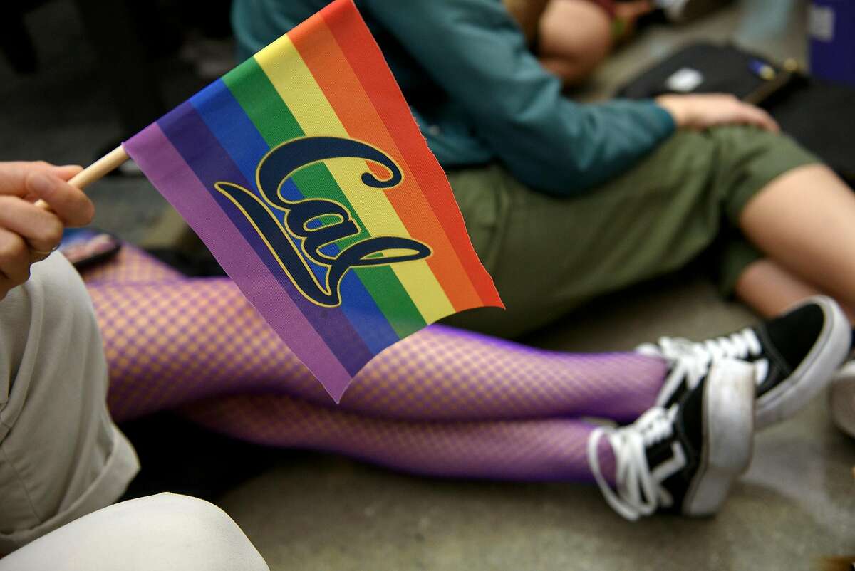 Student Lindsey Chung holds a Cal rainbow flag flags a while listening to speakers during a public comment portion of an Associated Students of the University of California meeting held at the University of California in Berkeley, Calif, on Wednesday November 7, 2018. Student Senator Isabella Chow is facing backlash for abstaining from a resolution condemning the Trump administration's anti-LGBTQ actions in new Title IX regulations.