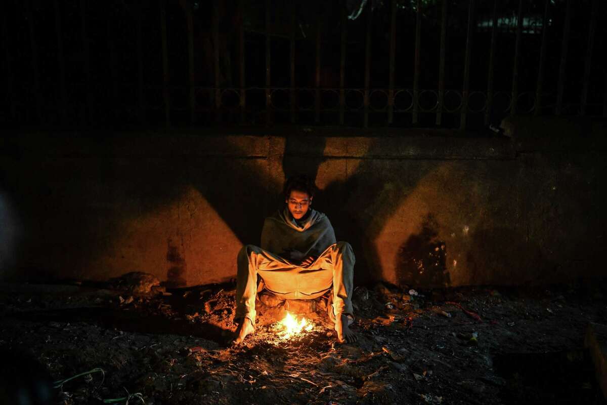 In this photograph taken on November 13, 2018 an Indian homeless man burns plastic to keep warm in the old quarters of New Delhi. - Homeless people bear the worst of the air pollution in New Delhi, the world's most polluted major city which has been covered in a toxic grey haze since the onset of winter last month. (Photo by CHANDAN KHANNA / AFP) / To go with INDIA-POLLUTION-ENVIRONMENT-HOMELESS videoCHANDAN KHANNA/AFP/Getty Images