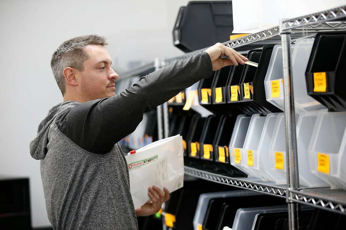 Garret Anderson, places product in the child-guard zip bags from the Eaze depot inventory storage as the order is placed at Caliva in San Jose, Calif., on Nov. 20, 2018. Uber, Lyft drivers are fleeing to become marijuana-delivery drivers � the new in-demand job in the on-demand economy. Caliva employs more than a hundred drivers. (Josie Lepe/Special to the Chronicle)