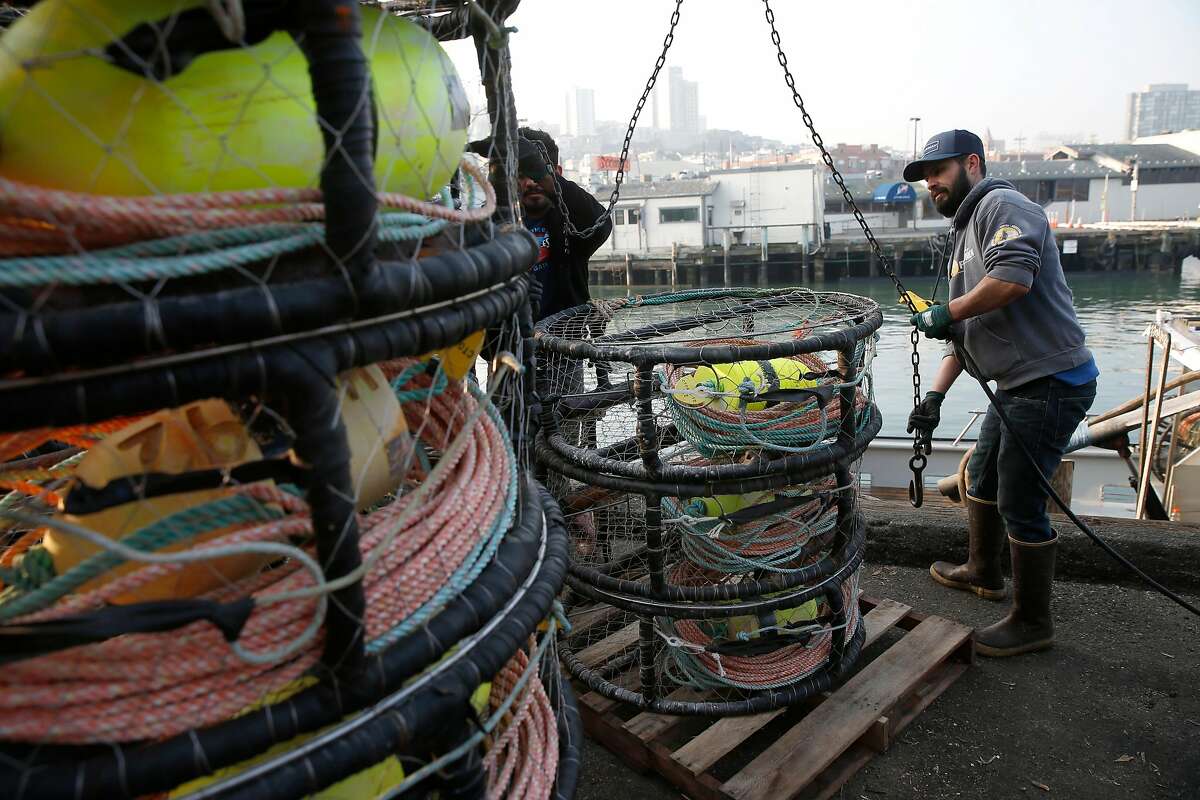 The crew of the New Rayann loads crab pots on the deck of the fishing boat at Pier 45 for the opening of the commercial crab season in San Francisco, Calif. on Wednesday, Nov. 14, 2018.
