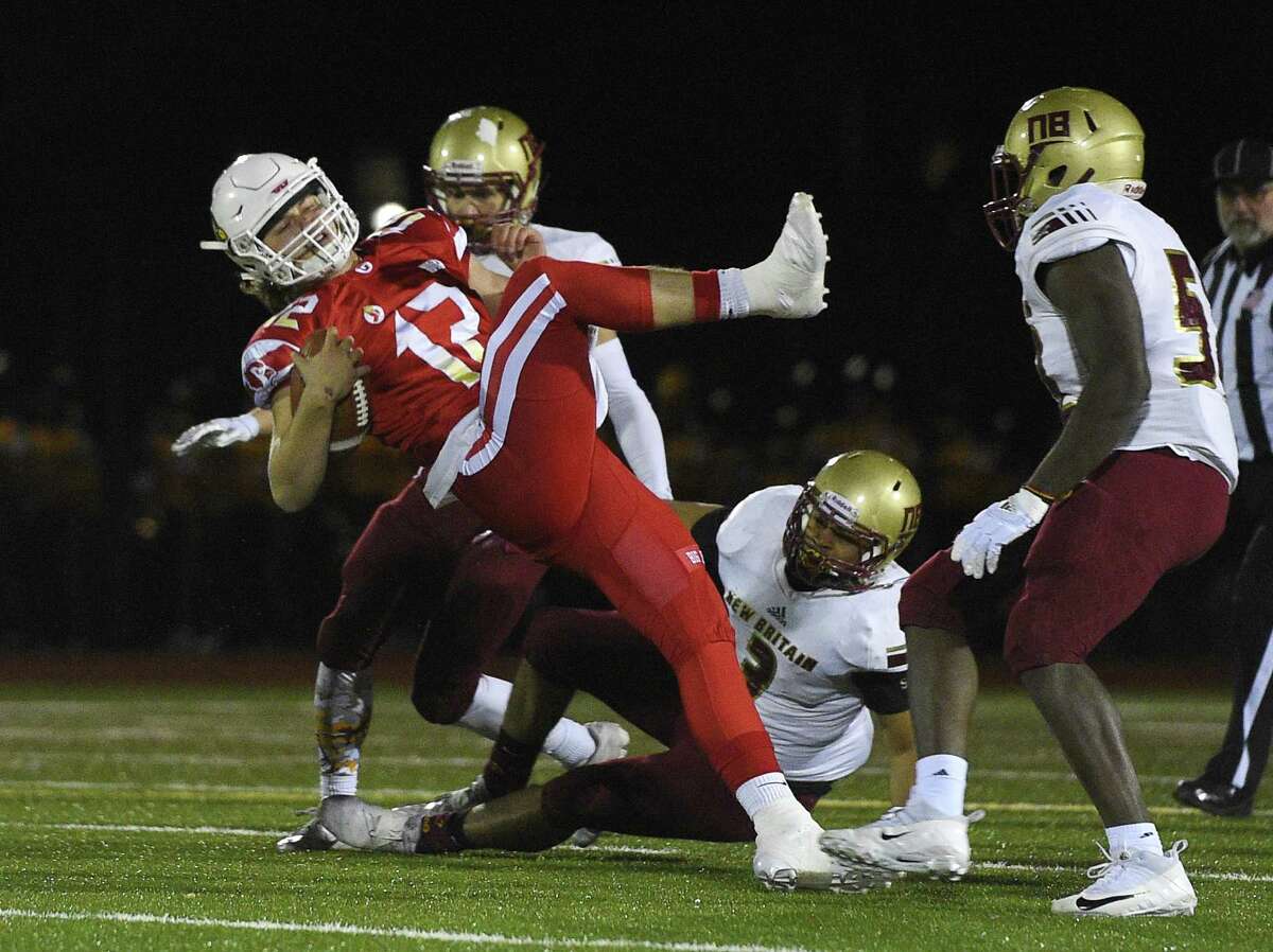 Greenwich quarterback Gavin Muir (12) breaks free against New Britain during a Class LL quarterfinal game on Tuesday night at Greenwich High School. The Cardinals won 49-13 and will play host to Newtown on Sunday in the semifinals.