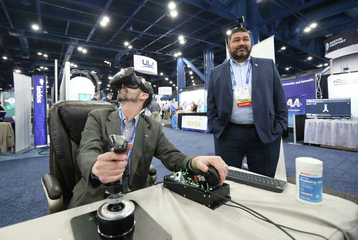 James Mireles, Aviar Techology, (left) flys a F-22 Fighter Jet out of Hobby Airport using Doug Watjus, MEI Technologies' Immersive Virtual Reality simulator at the annual SpaceCom (Space Commerce Conference and Exposition) Tuesday, Nov. 27, 2018, in Houston.