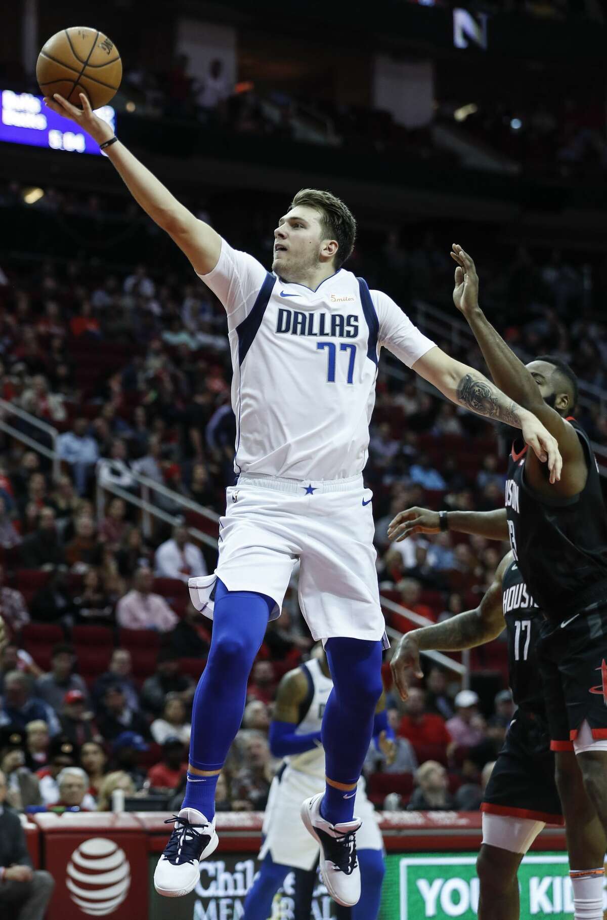 Dallas Mavericks forward Luka Doncic (77) shoots a layup after driving past Houston Rockets guard James Harden (13) during the second half of an NBA basketball game at Toyota Center on Wednesday, Nov. 28, 2018, in Houston.