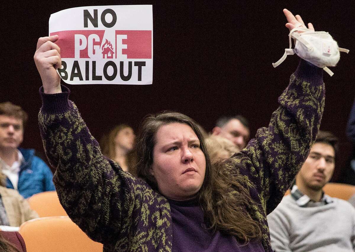 Masks Oakland founder Cassandra Williams raises her arms in protest during a California Public Utilities Commission meeting San Francisco, Calif. Wednesday, Nov. 28, 2018 surrounding the fate of PG&E following multiple deadly wildfires.