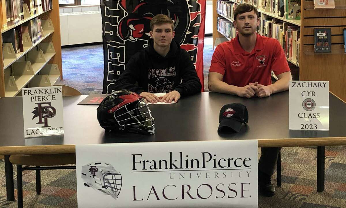 Zac Cyr, at left, announced he would play lacrosse at Franklin Pierce University next season. He is seated with Cromwell lacrosse coach Dan Vasquez.