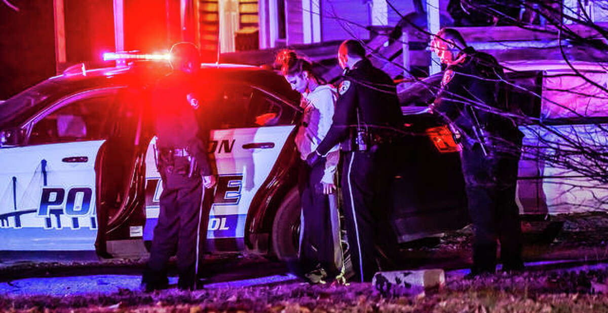 Police search a woman detained from the scene of a homicide investigation in the 3400 block of Boliver Street Thursday night. It was unclear if she was a person of interest or a possible witness.