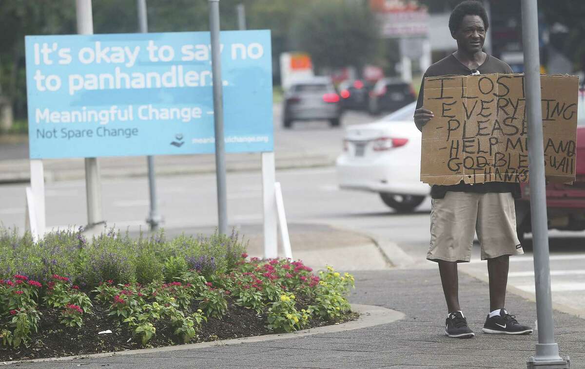 Tyron Davis panhandles despite a sign asking people not to give money near 610 and Westheimer on Friday, Sept. 21, 2018 in Houston.