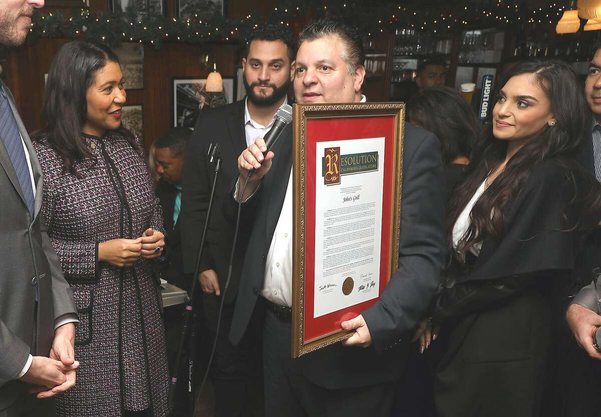 Mayor London Breed (left) with owner John Konstin and his son and daughter as he receives a certificate from Senator Scott Weiner as John's Grill celebrates its 110th anniversary on Thursday, Nov. 29, 2018, in San Francisco, Calif.