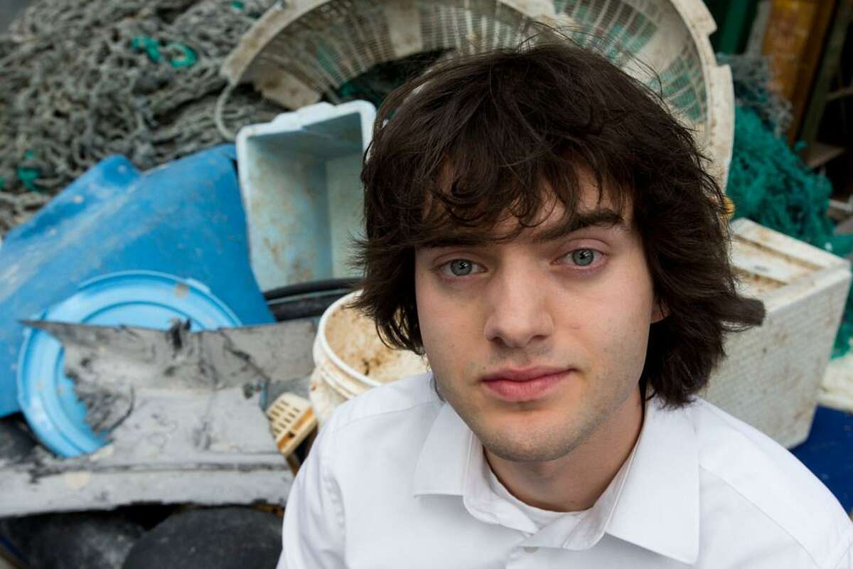 In this May 11, 2017, file photo, Dutch innovator Boyan Slat poses for a portrait next to a pile of plastic garbage prior to a press conference in Utrecht, Netherlands. Engineers will deploy a trash collection device to corral plastic litter floating between California and Hawaii in an attempt to clean up the world's largest garbage patch in the heart of the Pacific Ocean. The 2,000-foot (600-meter) long floating boom will be towed Saturday, Sept. 8, 2018, from San Francisco to the Great Pacific Garbage Patch, an island of trash twice the size of Texas. The system was created by The Ocean Cleanup, an organization founded by Slat. (AP Photo/Peter Dejong, File)