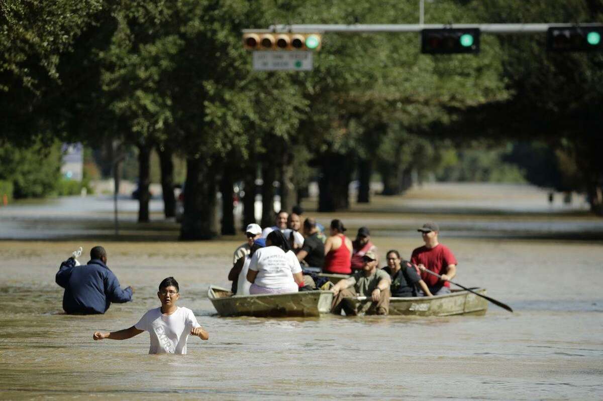People evacuate a neighborhood inundated by water released from Addicks Reservoir after it reached capacity due to Tropical Storm Harvey on Aug. 30, 2017, in Houston.