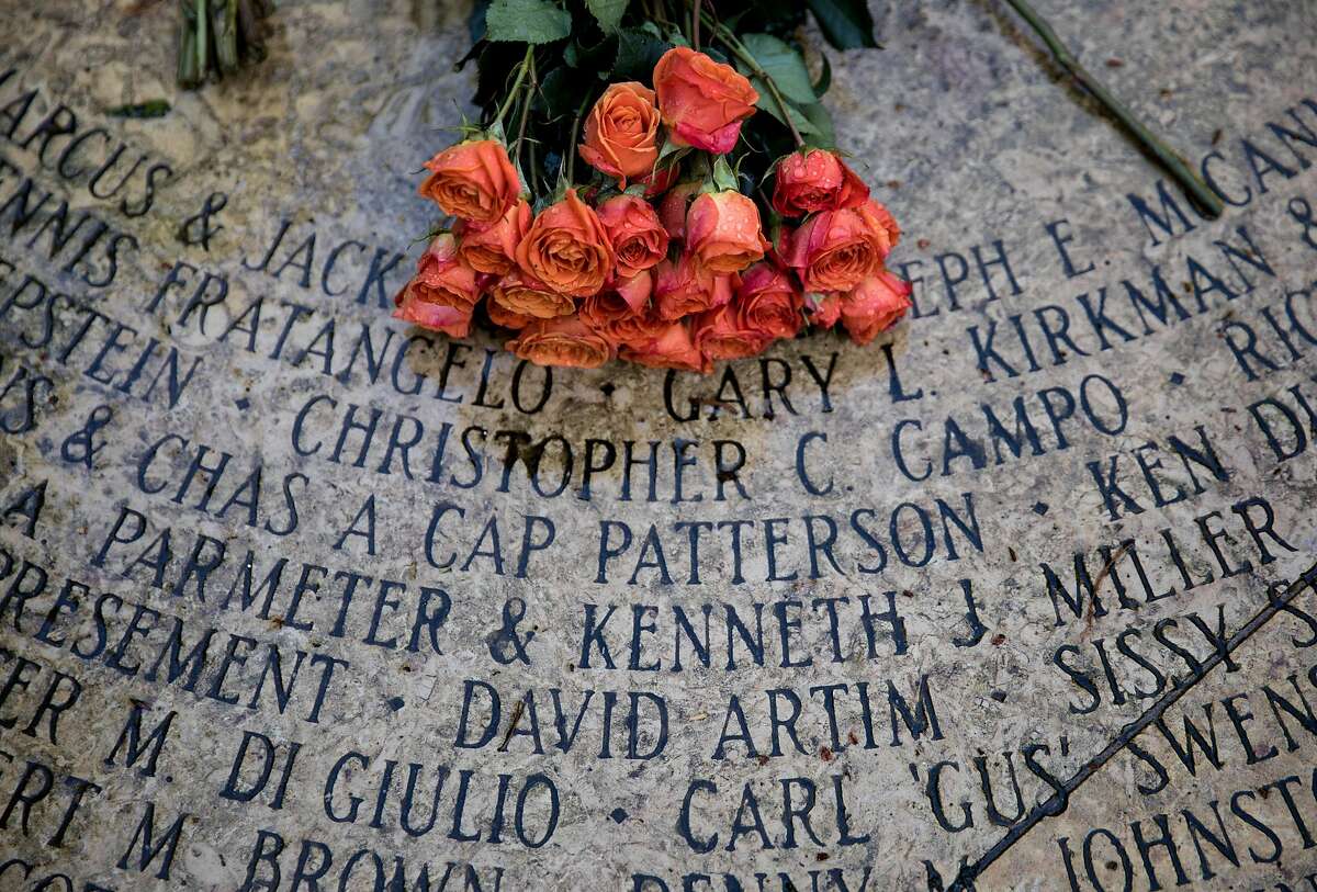 Names are etched into the Circle of Friends near a bouquet of flowers placed during an observance of World Aids Day held at the National Aids Memorial Grove at Golden Gate Park in San Francisco, Calif. Saturday, Dec. 1, 2018.