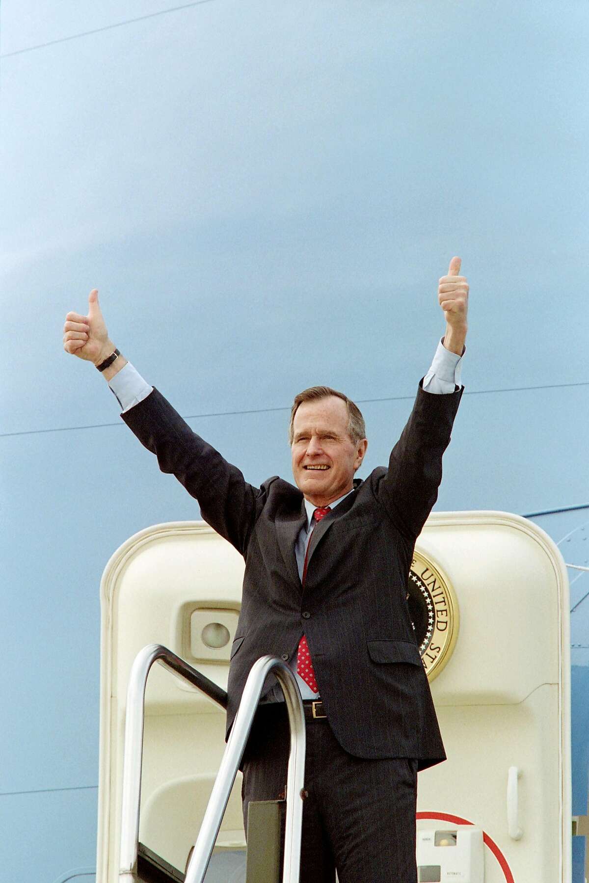 (FILES) In this file photo taken on March 05, 1992 US President George Bush acknowledges the crowd gathered at Columbia Metropolitan Airport with a thumbs-up as he boards Air Force One upon his departure. - Former US president George H.W. Bush, who helped steer America through the end of the Cold War, has died at age 94, his family announced late Friday November 30, 2018. "Jeb, Neil, Marvin, Doro and I are saddened to announce that after 94 remarkable years, our dear Dad has died," his son, former president George W. Bush, said in a statement released on Twitter by a family spokesman. (Photo by Luke FRAZZA / AFP)LUKE FRAZZA/AFP/Getty Images