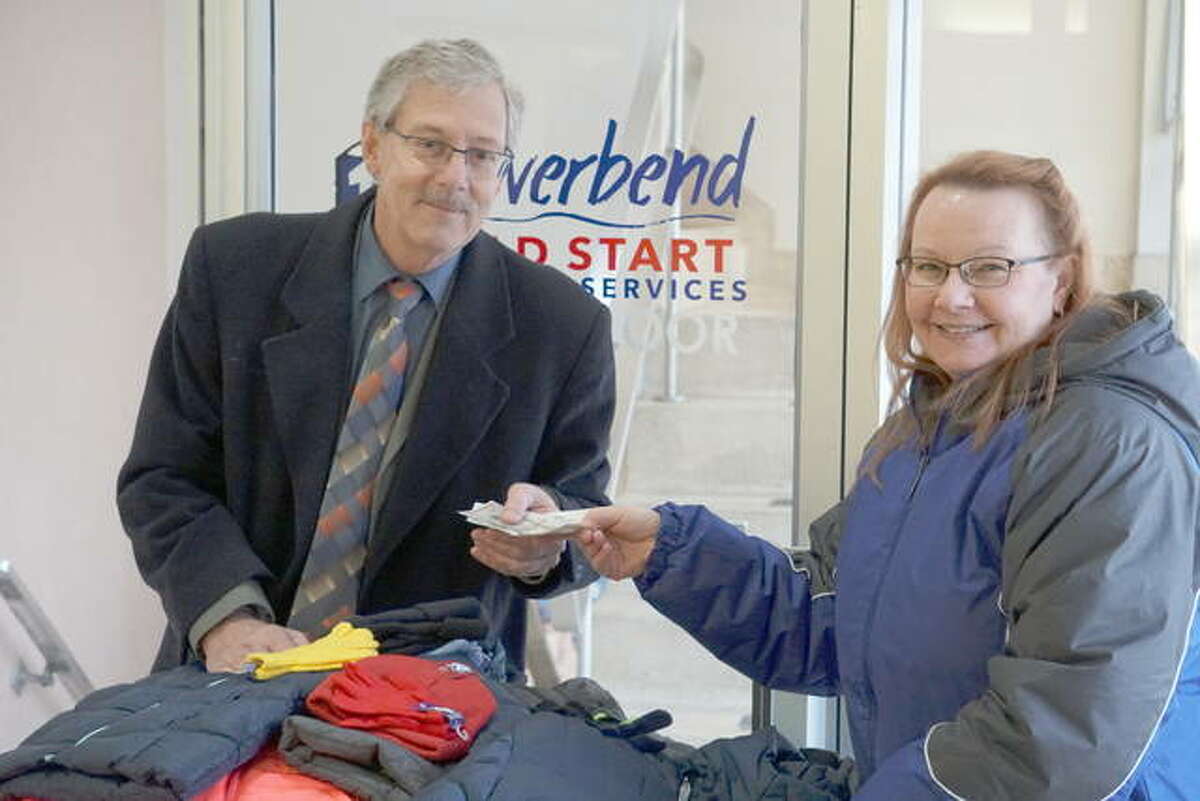 Tim Hinrichs of Alton-Godfrey Rotary delivers coats and cash to Judy Gann for the Riverbend Head Start & Family Services’ annual Coats for Kids drive.