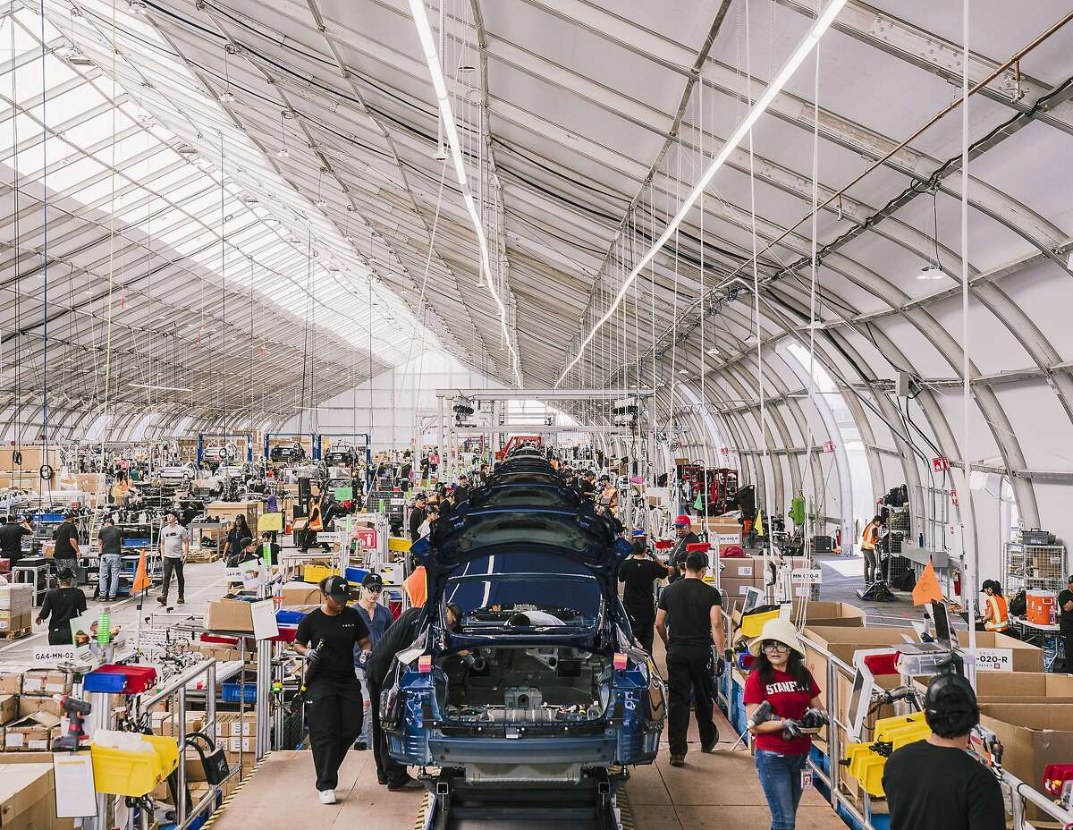 FILE -- Workers assemble Model 3s in a tent at Tesla's factory in Fremont, Calif., June 28, 2018. African-American workers have reported threats, humiliation and barriers to promotion at the plant. The automaker says there is no pattern of bias. (Justin Kaneps/The New York Times)