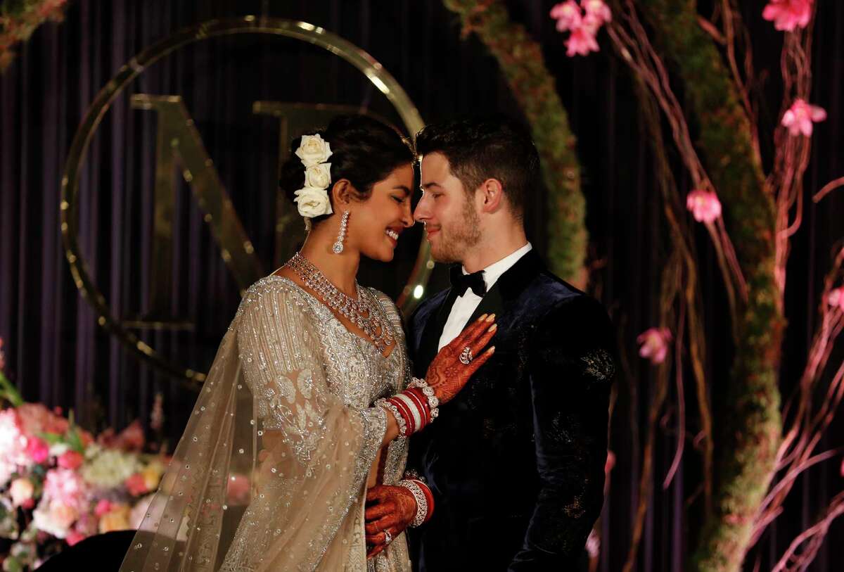Bollywood actress Priyanka Chopra and musician Nick Jonas stand for photographs at their wedding reception in New Delhi, India, Tuesday, Dec. 4, 2018. (AP Photo/Altaf Qadri)