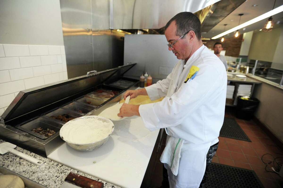 Teena’s Apizza co-owner and chef Derek Furino makes a fresh pizza in June.