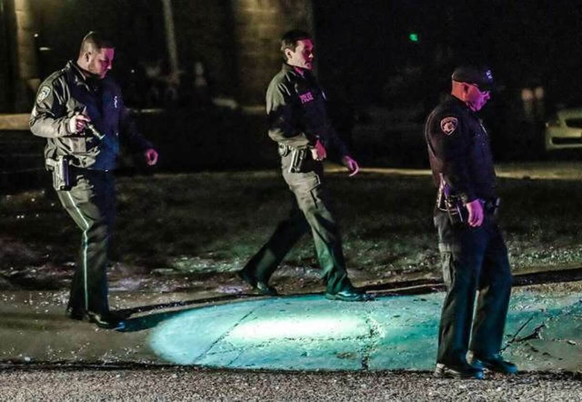 Alton police officers search the to the 800 block of Ridge Street last Thurday night after a man was shot during an altercation. A suspect in the shooting was charged Tuesday.