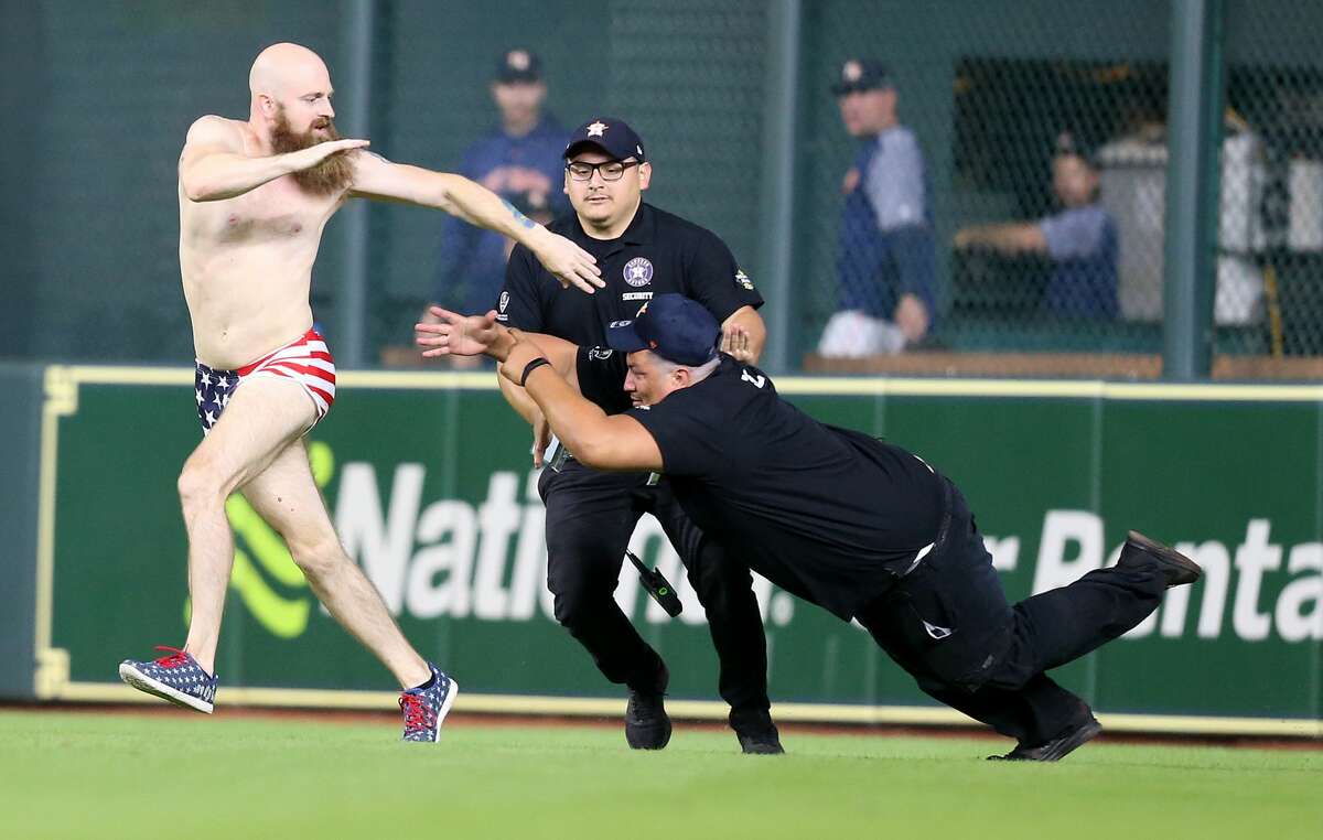An attendee of the Houston Astros game dodges security after the Astros loss to the Texas Rangers 11-2 at Minute Maid Park on Friday, July 27, 2018 in Houston.