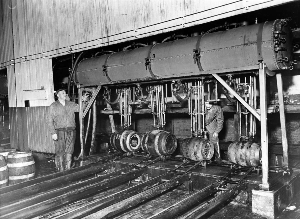 "In preparation for the return of real beer, the famous Jacob Ruppert Brewery in New York is humming with activity. All machinery is being overhauled and tested for manufacture of the Pre-Prohibition brand of beer. Photo shows Fred Kaufman (left) and Joseph Dobler, old time brewers, with the machine used for barrelling and capping beer in the Ruppert Brewery." Taken November 16, 1932. (Times Union Archive)