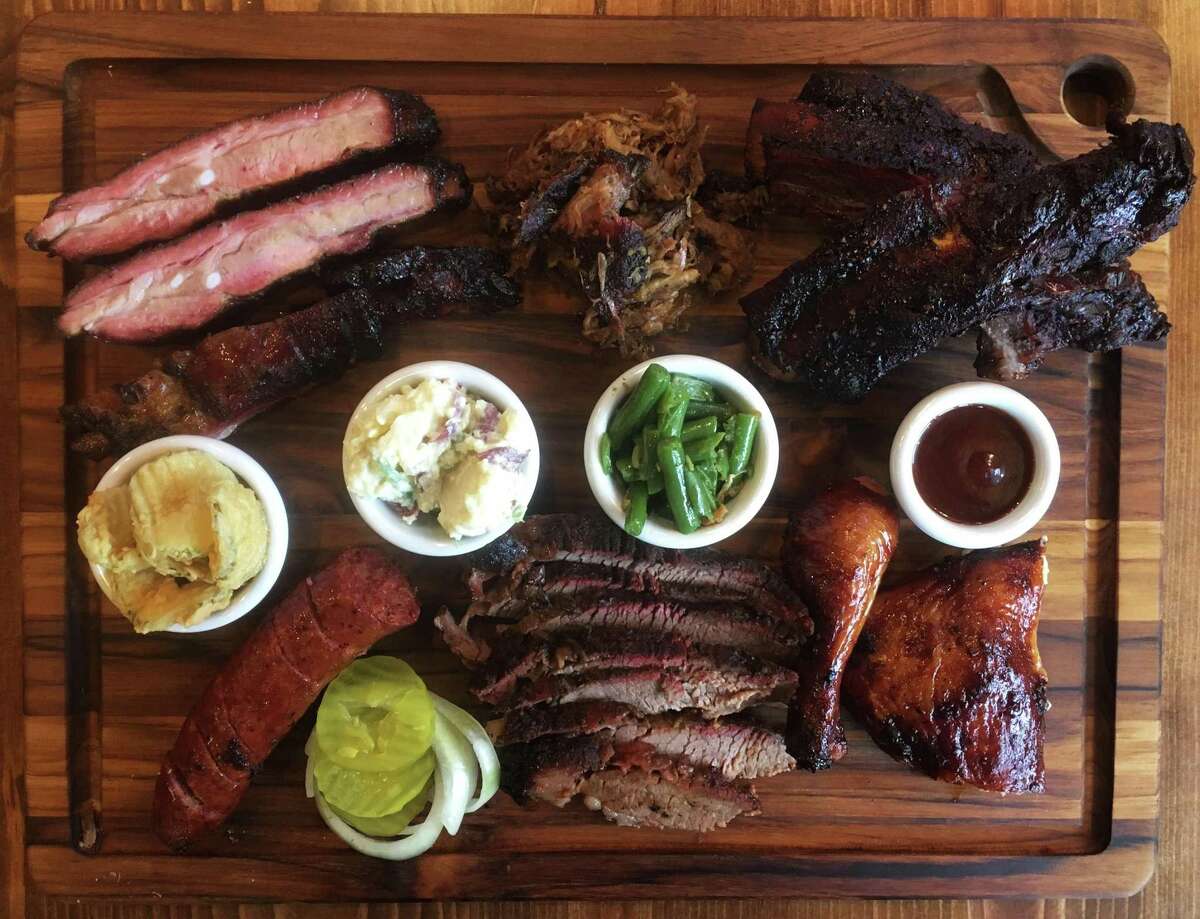 The board at B&B Smokehouse includes (from top left): Pork spare ribs, pulled pork, beef ribs, chicken, brisket, green beans, potato salad, sausage and fried pickles.